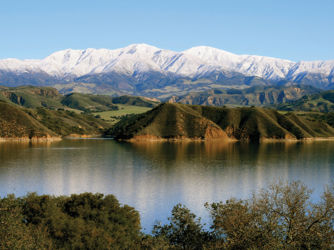 Winter 2011 photo of a full Lake Cachuma with snowy peaks in the background.